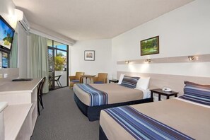 A hotel room with two beds, a desk, a chair, a small table, and a TV. - East Port Motor Inn (Port Macquarie)