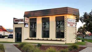 A motel with a sign indicating 'Deluxe Rooms Now Available'. - Ryley Motor Inn (Wangaratta)