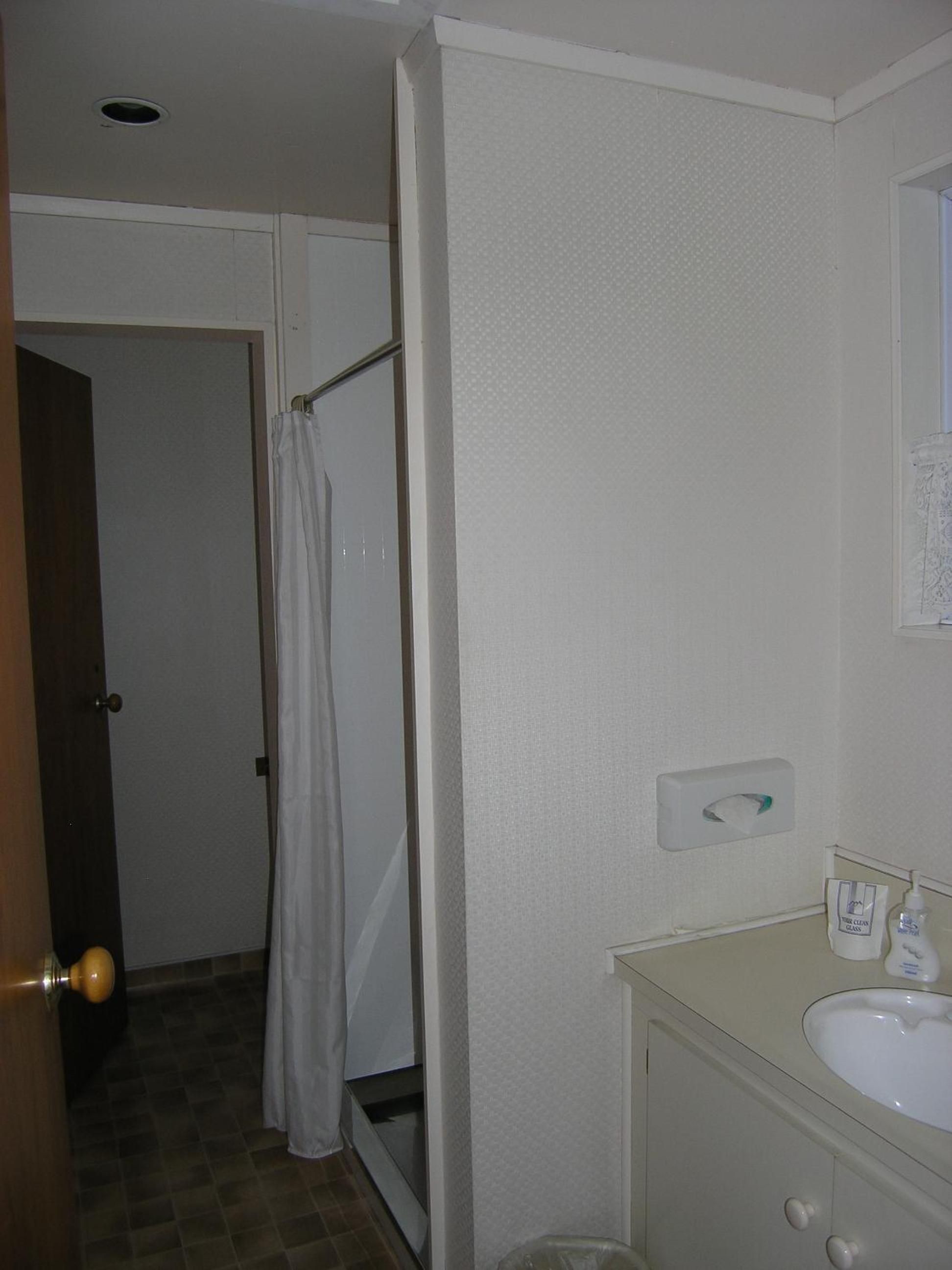 A bathroom with a shower, toilet, and sink.