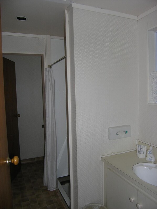 A bathroom with a shower, toilet, and sink.