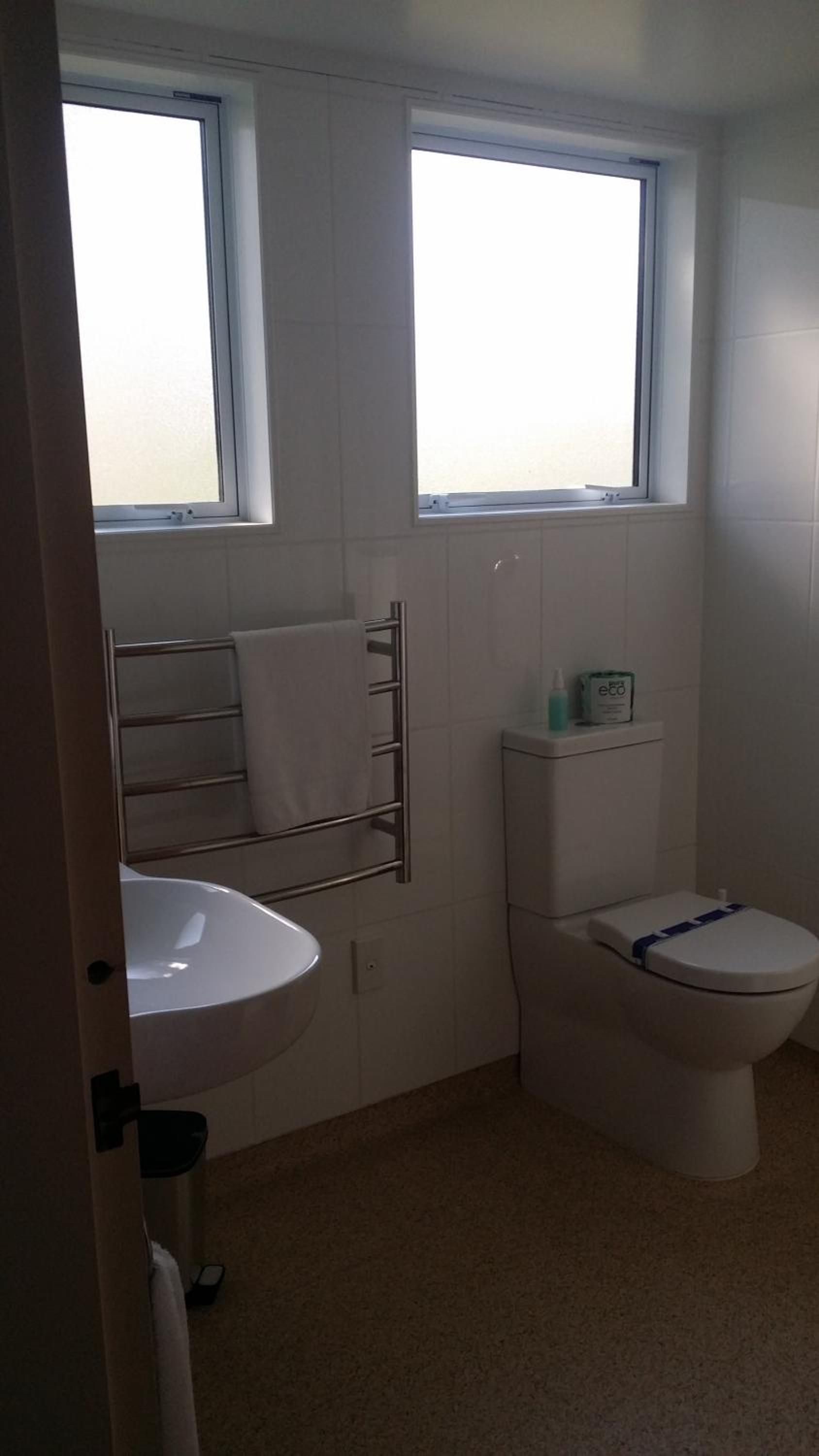 Ein Badezimmer mit Toilette, Waschbecken und Handtuchhalter.