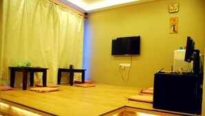 A room with a stage area, a television mounted on the wall, and a small table with a chair. - Hotel O V Stay Guesthouse (George Town)