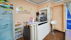A guest house interior with a reception desk, a refrigerator, and a mirror. - Hotel O V Stay Guesthouse (George Town)