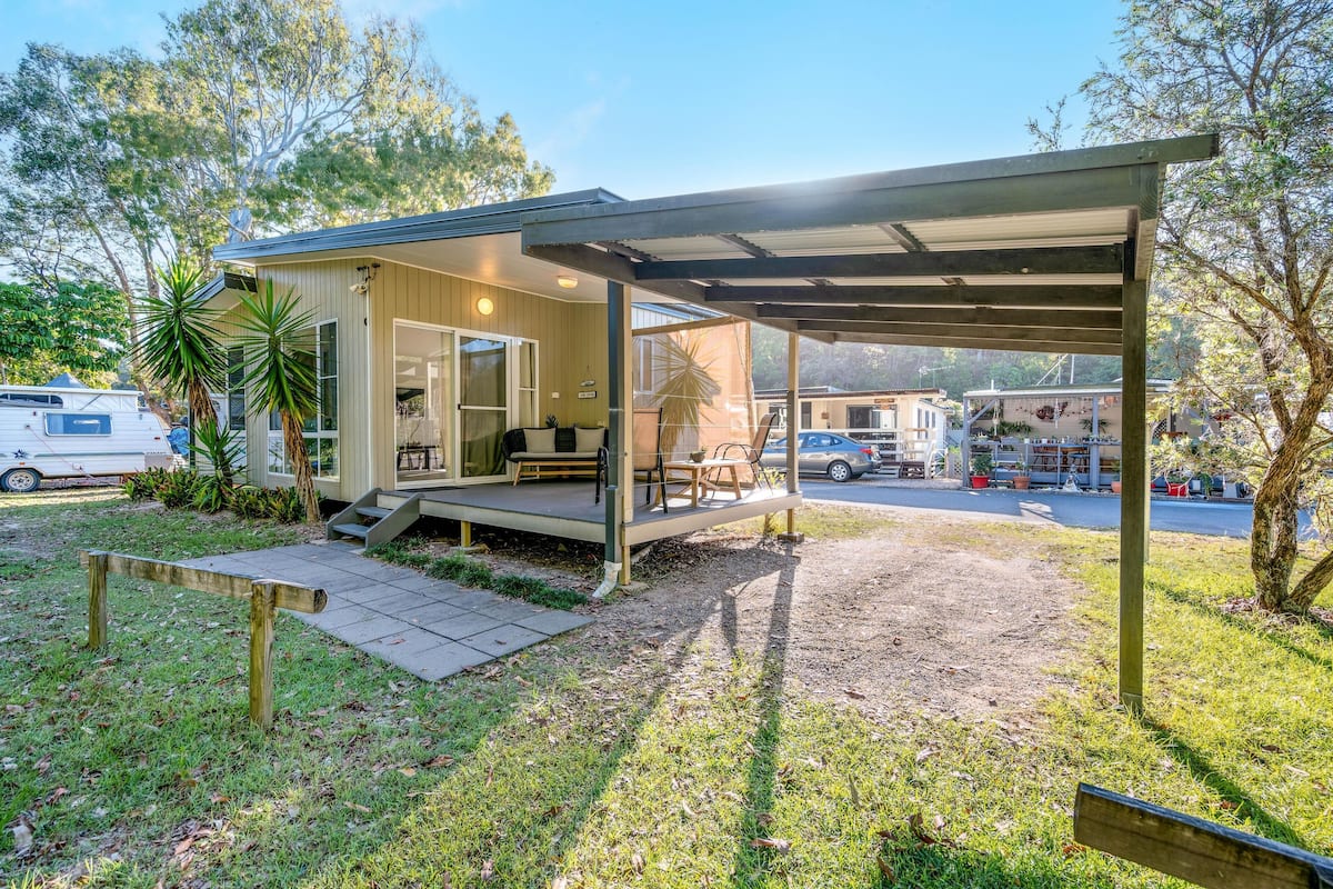 A single-story house with a covered porch, a patio, and a small garden area.