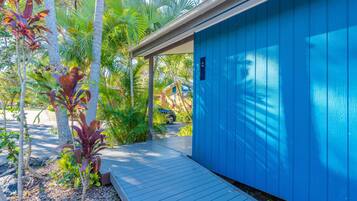 A blue building with a covered porch and a wooden deck.