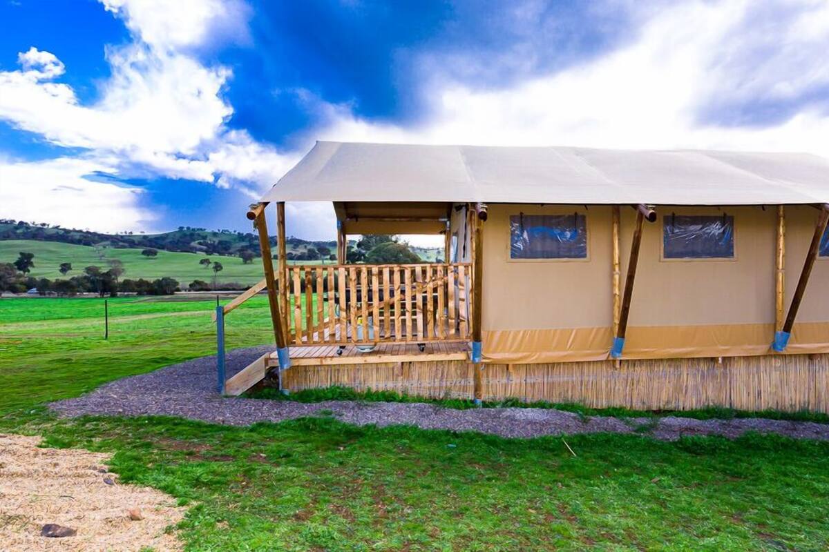 A tent-style accommodation with a wooden deck and a covered entrance.