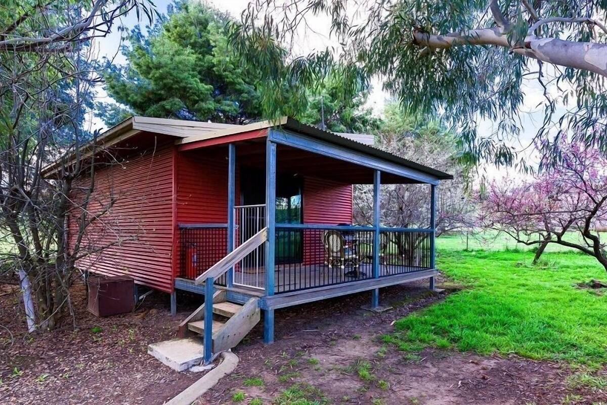 A small, single-story cabin with a porch and a staircase leading to the entrance.