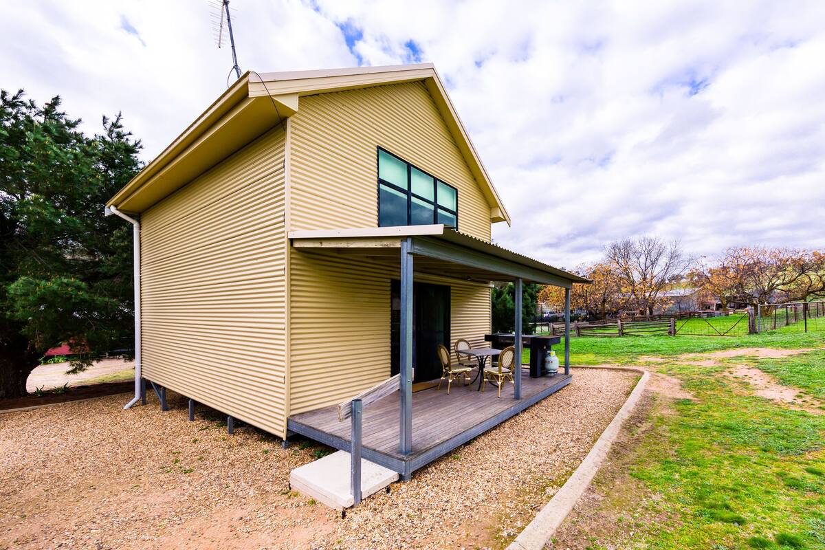A modern two-story house with a covered patio area.