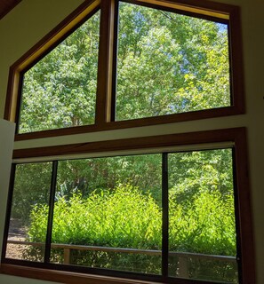 Una habitación con un ventanal amplio que da a un paisaje verde y exuberante.