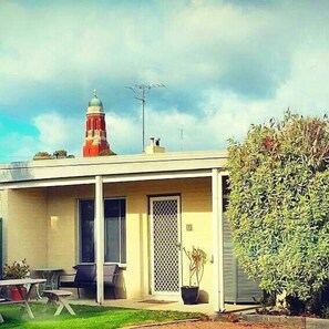 A house with a covered porch, a red tower-like structure, and a potted plant. - Bairnsdale Town Central Motel (Bairnsdale)