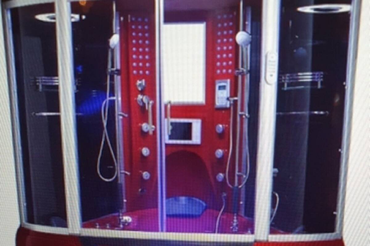 A red and black room with a circular layout, featuring a central control panel and two doors.