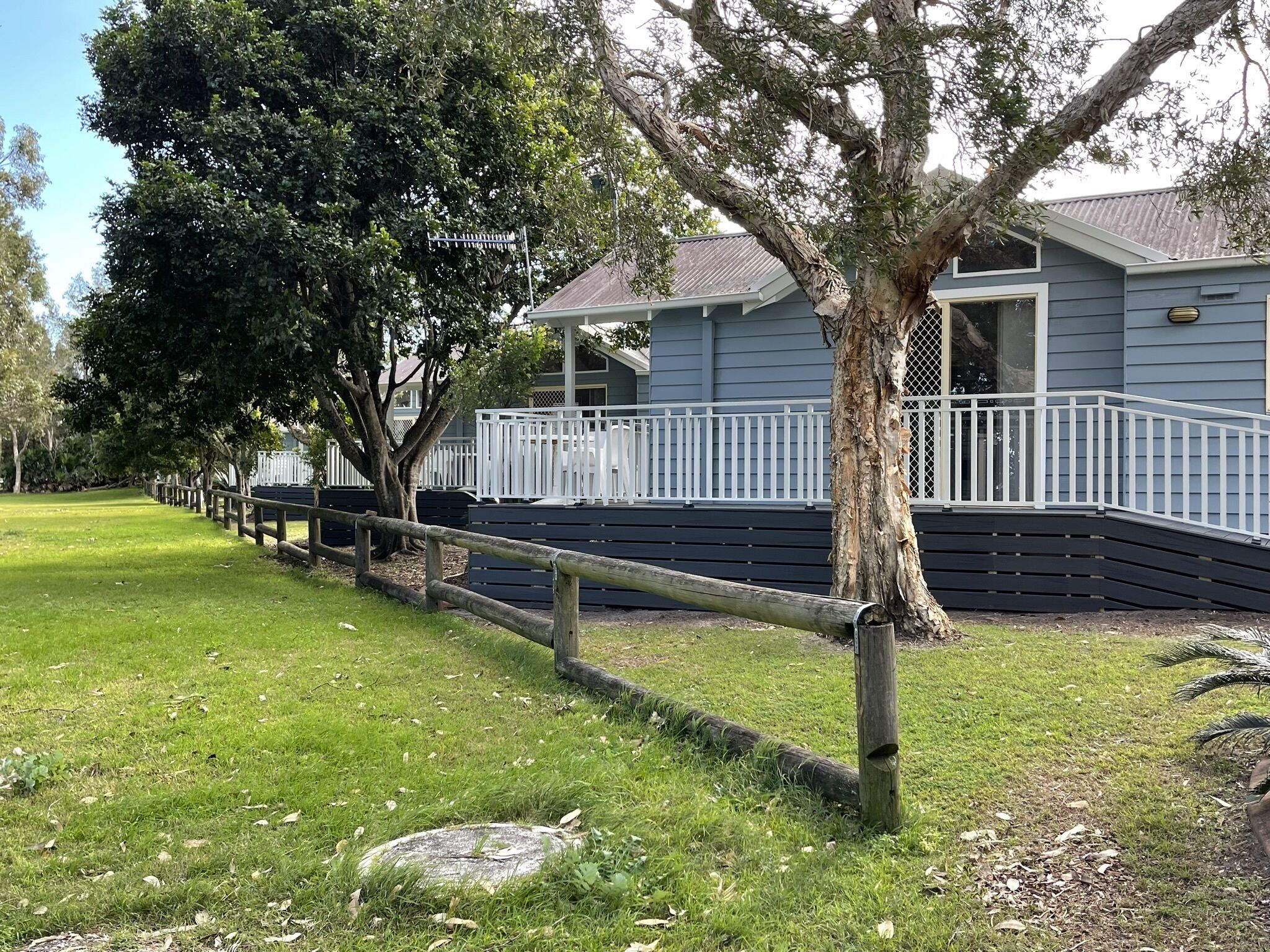 A house with a porch, a fence, and trees.