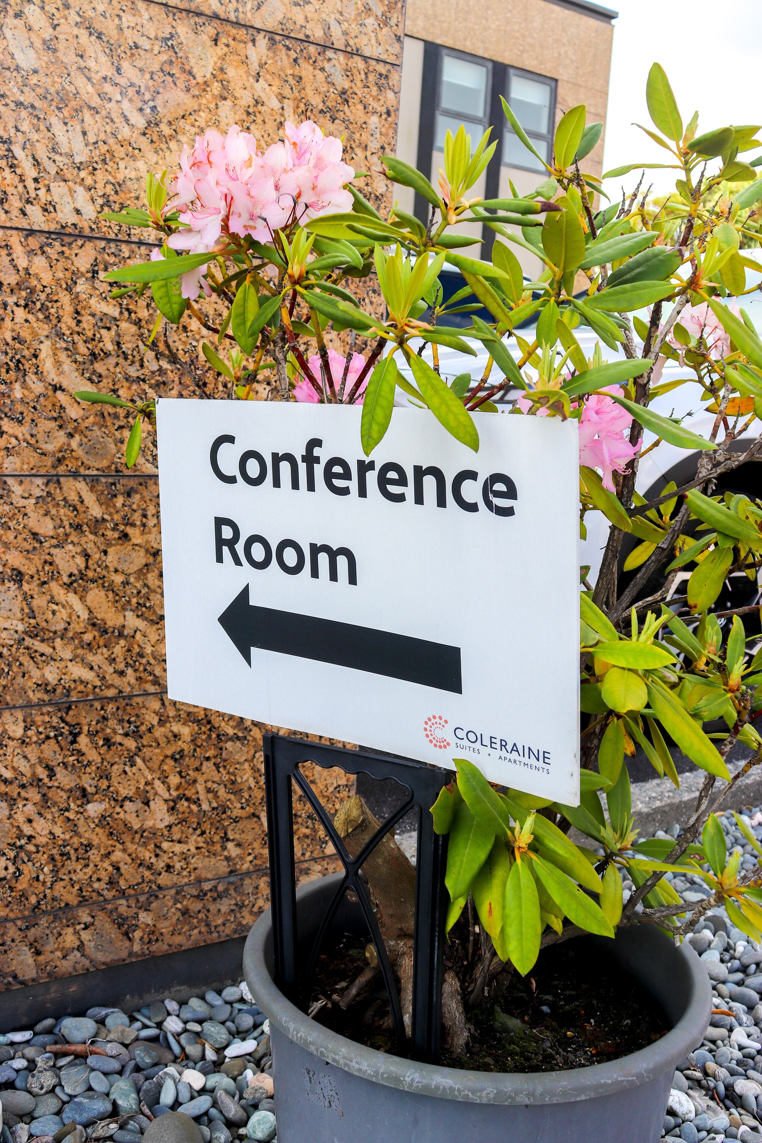 A sign for a conference room with an arrow pointing to the left.