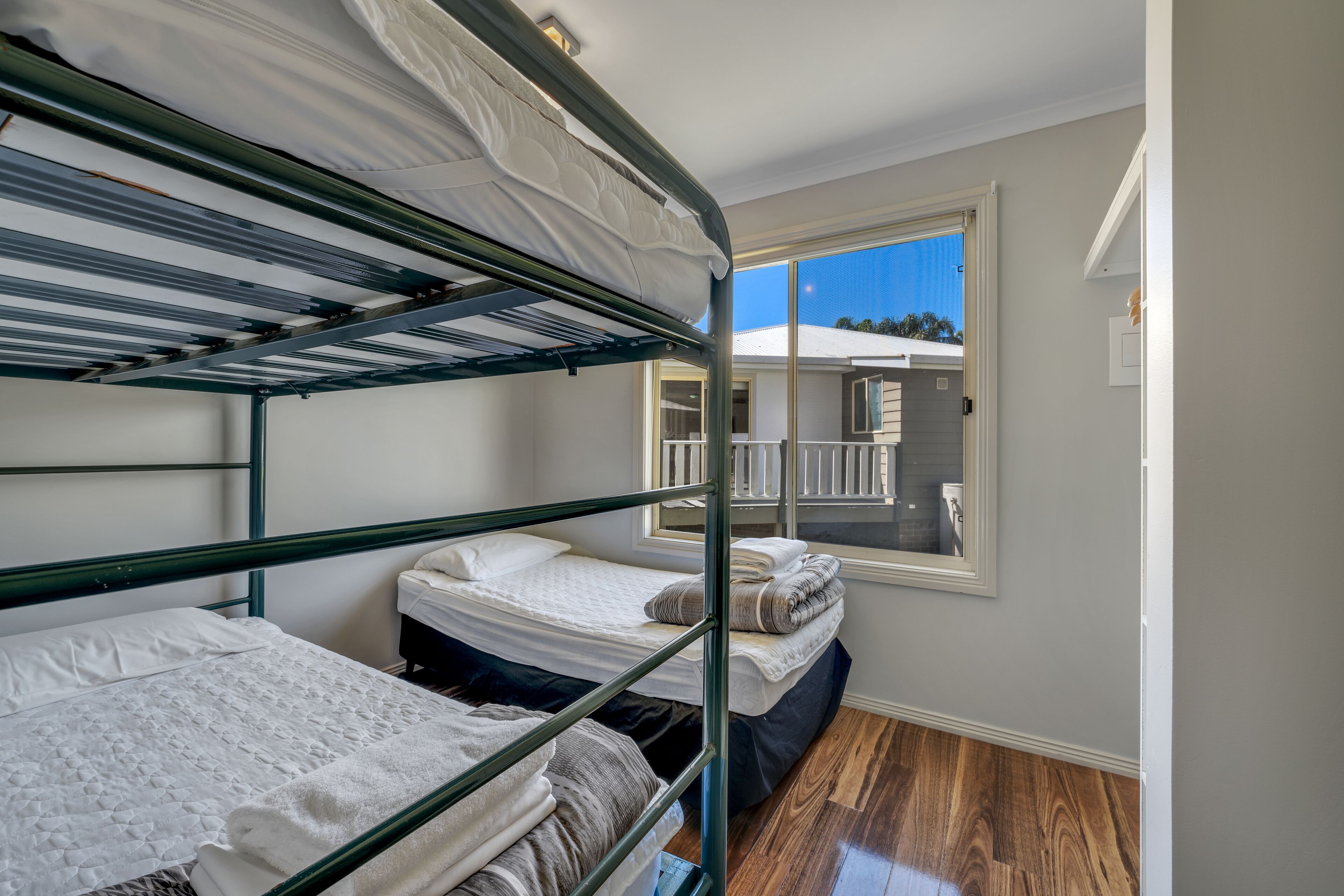 Habitación con literas y vista a un balcón y un edificio.