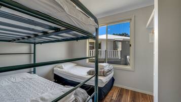 Habitación con literas y vista a un balcón y un edificio.