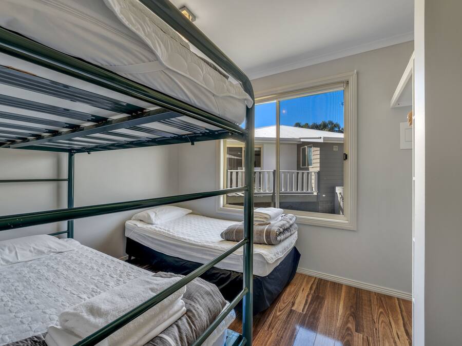 Habitación con literas y vista a un balcón y un edificio.