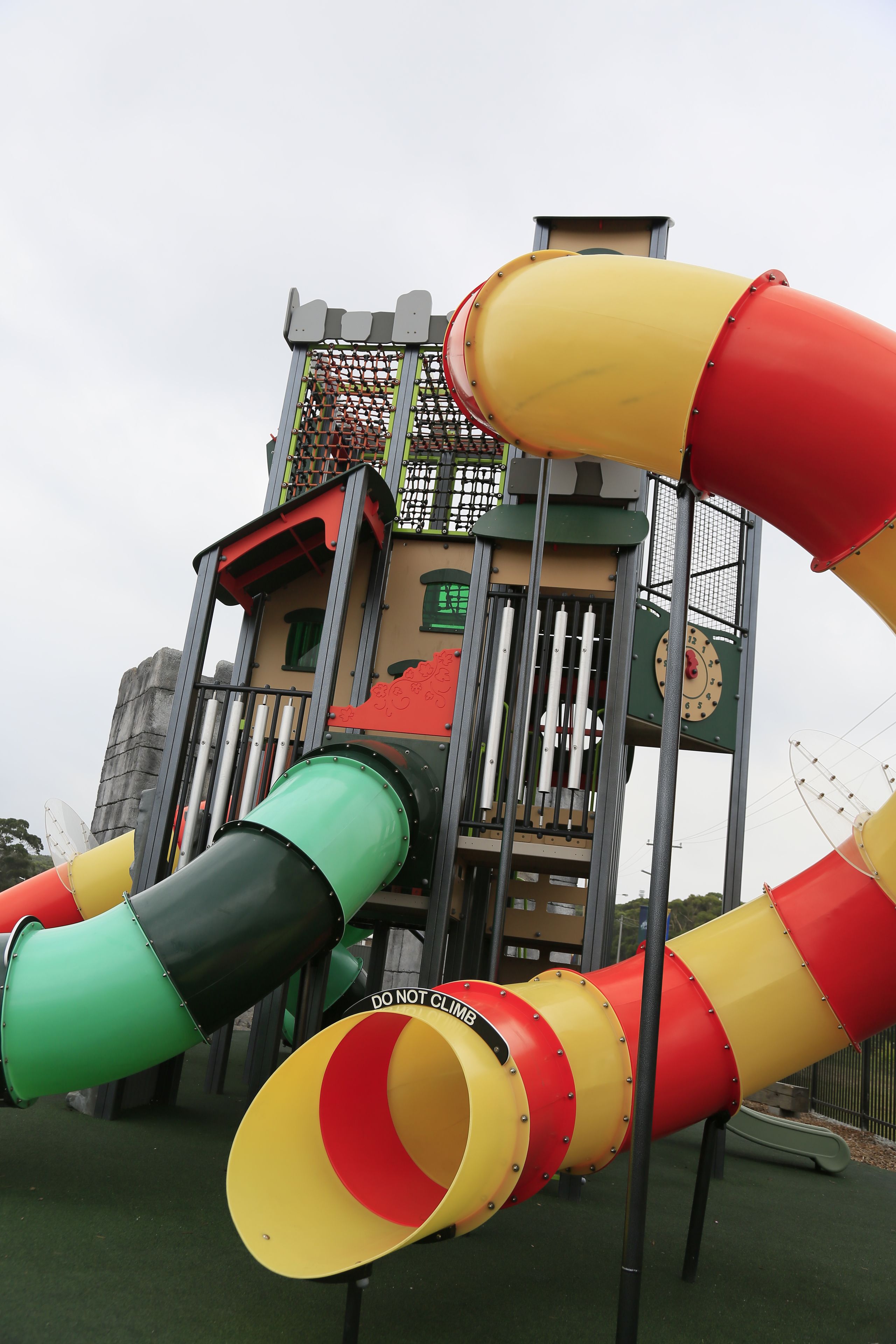 Un parque infantil con toboganes y una estructura que parece un castillo al fondo.