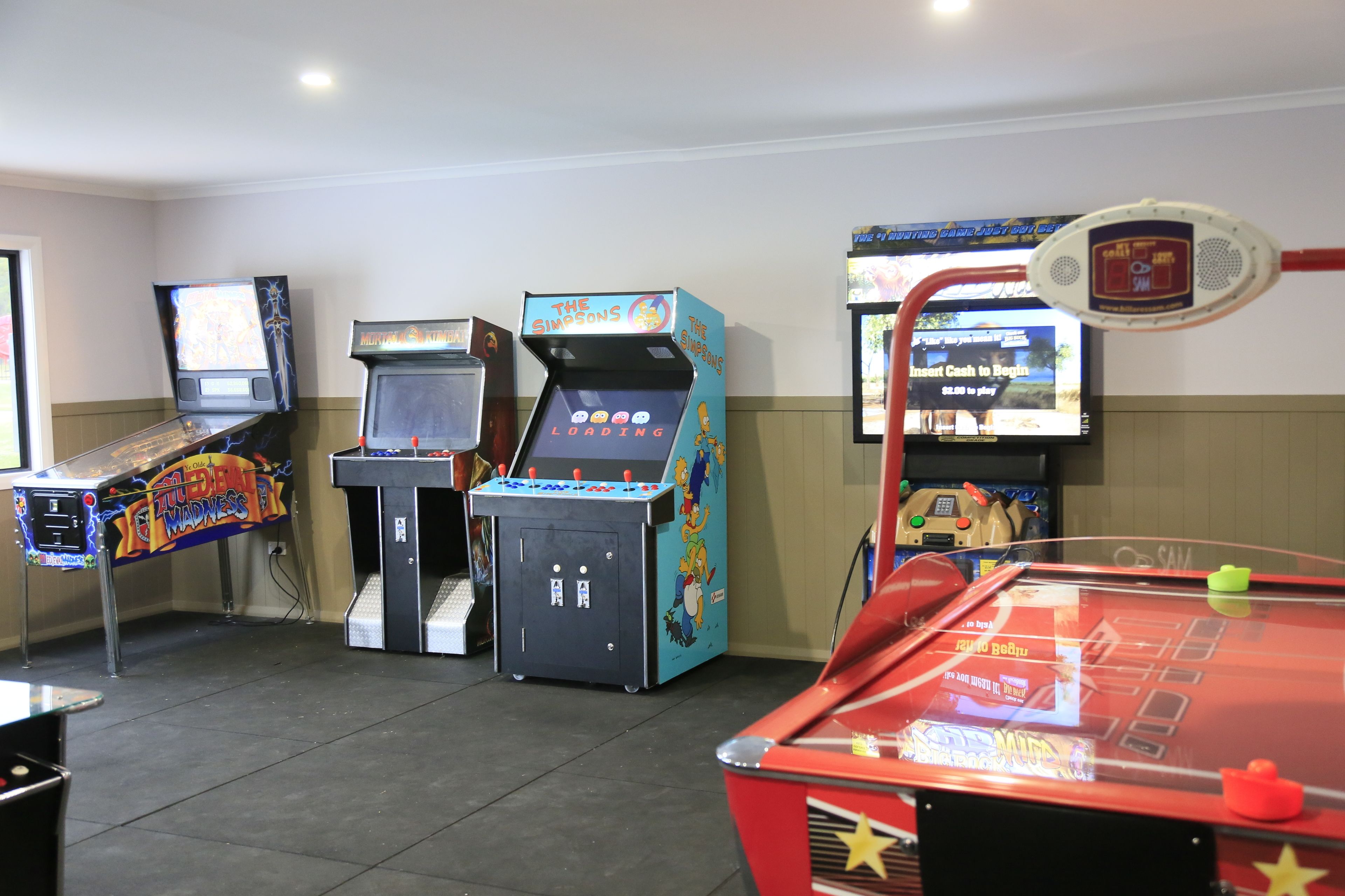 A room with arcade games including 'The Simpsons' and 'Teenage Mutant Ninja Turtles'.
