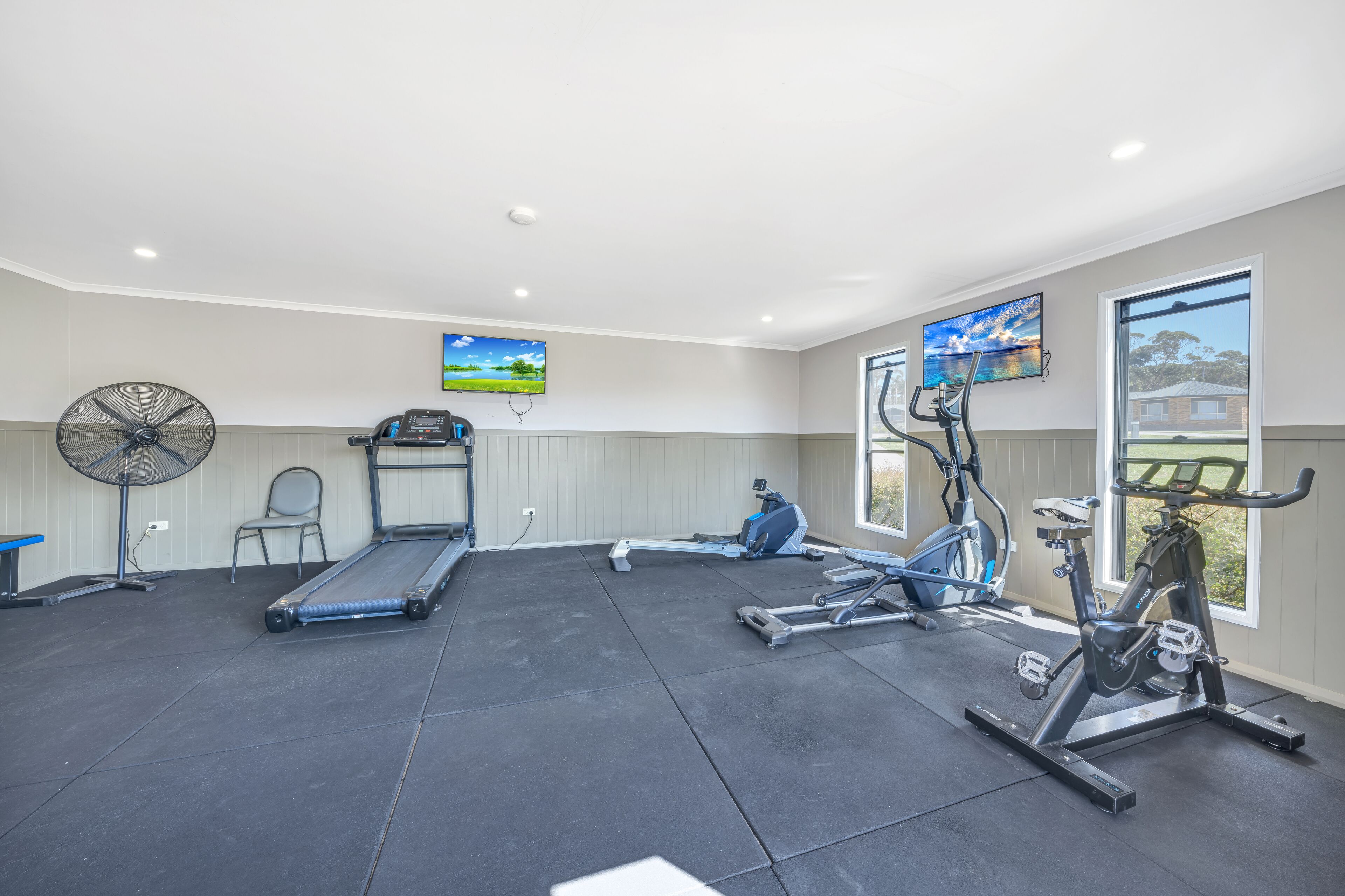 A gym with treadmills, stationary bikes, and a rowing machine.