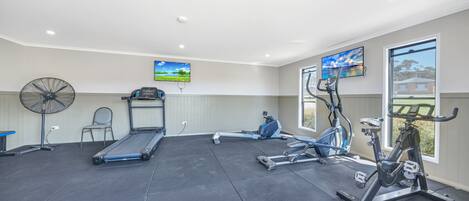 A gym with treadmills, stationary bikes, and a rowing machine.