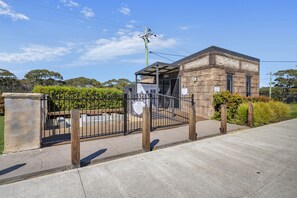 A stone building with a covered entrance and a signboard.