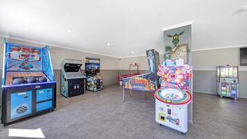 Una habitación con juegos de arcade, un aro de baloncesto y un cartel en la pared.