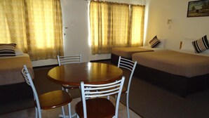 Um espaço compacto com área de jantar, sofá e cama.