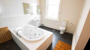 Een moderne badkamer met een vrijstaand bad, een wastafel en een toilet.