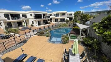 Una piscina al aire libre, sillones reclinables de piscina