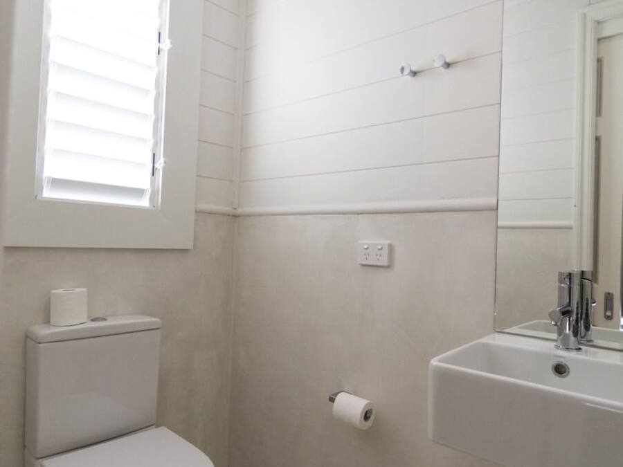 A bathroom with a toilet, a sink, and a window.