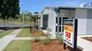 A modern building with a sign for Springsure Dooleys Restaurant and Motel, indicating a drive-through service.