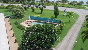 A pool area with benches and a sign for a nearby motel. - Ocean View Motel Bowen (Bowen)