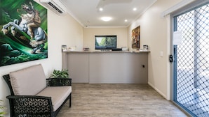 A modern kitchen with a flat-screen TV, a dining area with a cushioned bench, and a large window with a view. - Athena Studio Units (Roma)