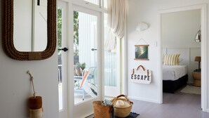A room with a bed, a large mirror, a door leading outside, and a wall with a sign that says "ESCAPE". - Blue Water Motel (Kingscliff)