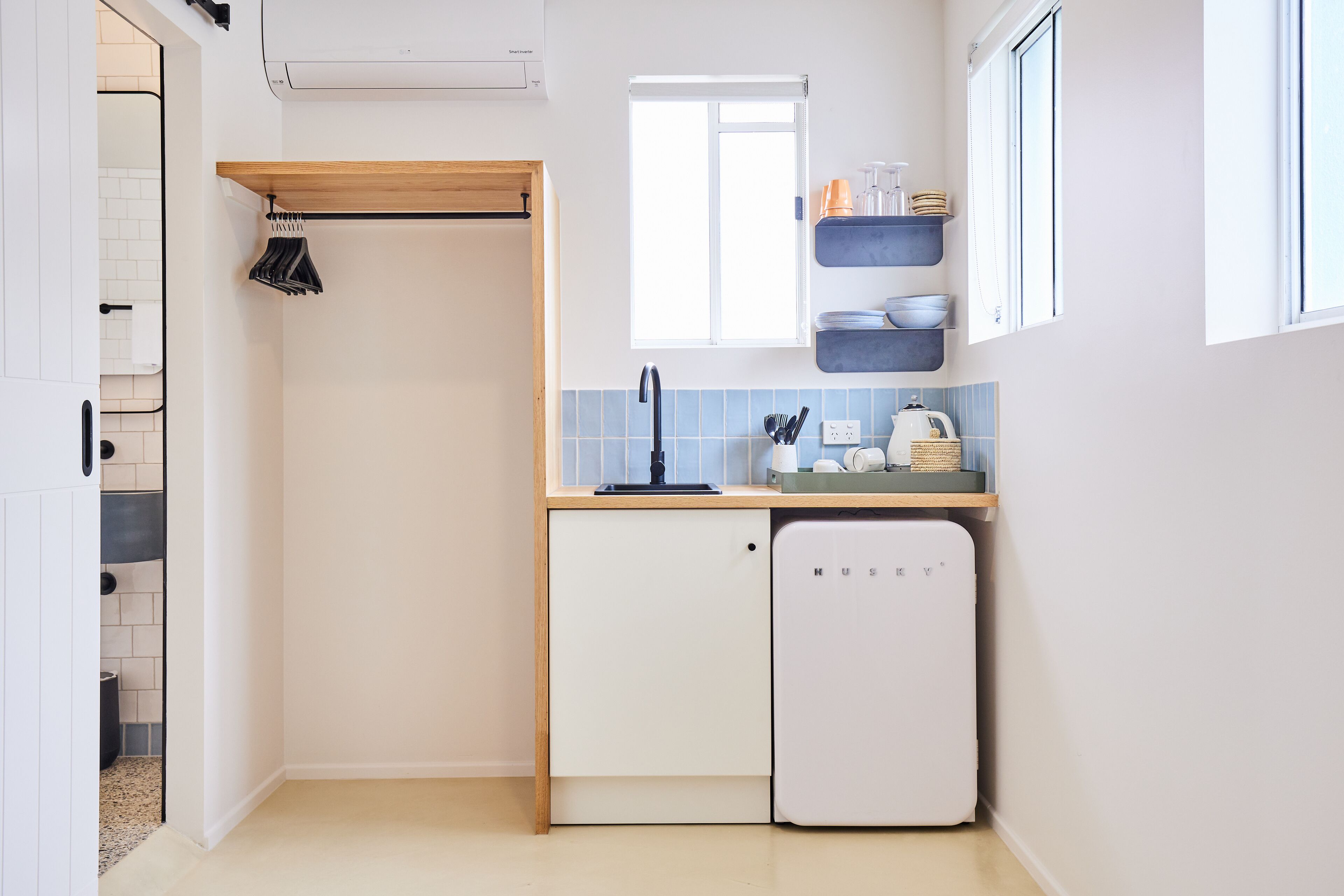 A compact kitchen with a built-in dishwasher, a window above the sink, and a small countertop with kitchen essentials.