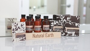 Eine Präsentation von Natural Earth Produkten, darunter Duschgel, Conditioner und Badesalz.
