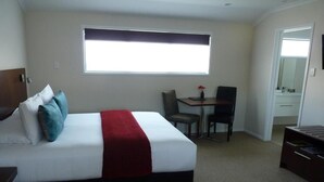 Ein Hotelzimmer mit Bett, Schreibtisch und Stuhl.