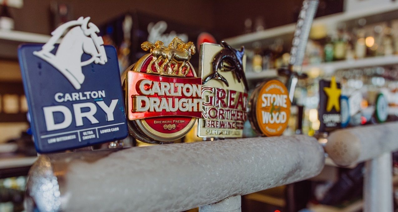 A bar shelf with various beer taps, including Carlton Draught and Stone Wood.
