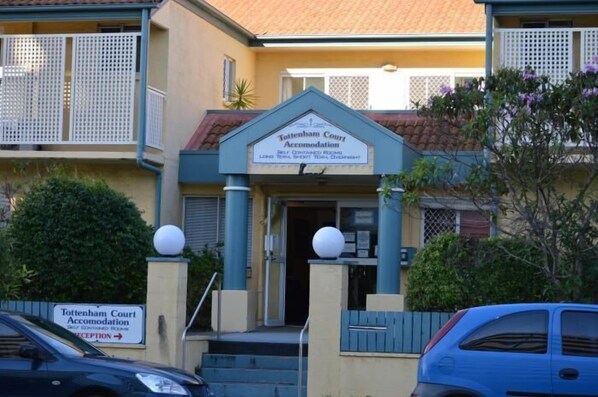 A building labeled 'Tottenham Court Accommodation' with a sign indicating self-contained rooms and a reception area. - Tottenham Court Accommodation (Woolloongabba)
