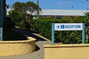 A reception sign with an arrow pointing upwards, indicating the direction to the reception area. - Tottenham Court Accommodation (Woolloongabba)