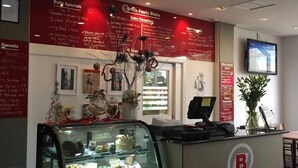 Una barra de panadería con un cartel que muestra las ofertas del día y algunos clásicos.