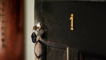 Primer plano de una puerta con cerradura de latón y ojo de cerradura.