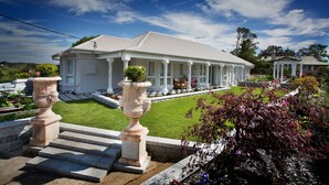 A large, white, two-story house with a covered porch and a well-maintained lawn. - Katoomba Manor (Katoomba)