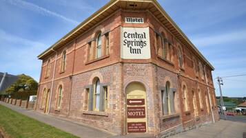 A brick building with a sign reading "Central Springs Inn Motel" and "Spa Suites Open Fire Suites Conference Room."