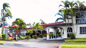 A two-story building with a covered entrance, large windows, and a red-tiled roof. - Tropic Coast Motel (West Mackay)