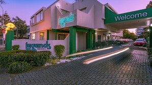 Un Legends Motel con un cartello accogliente, un'antenna parabolica e un ingresso asfaltato.
