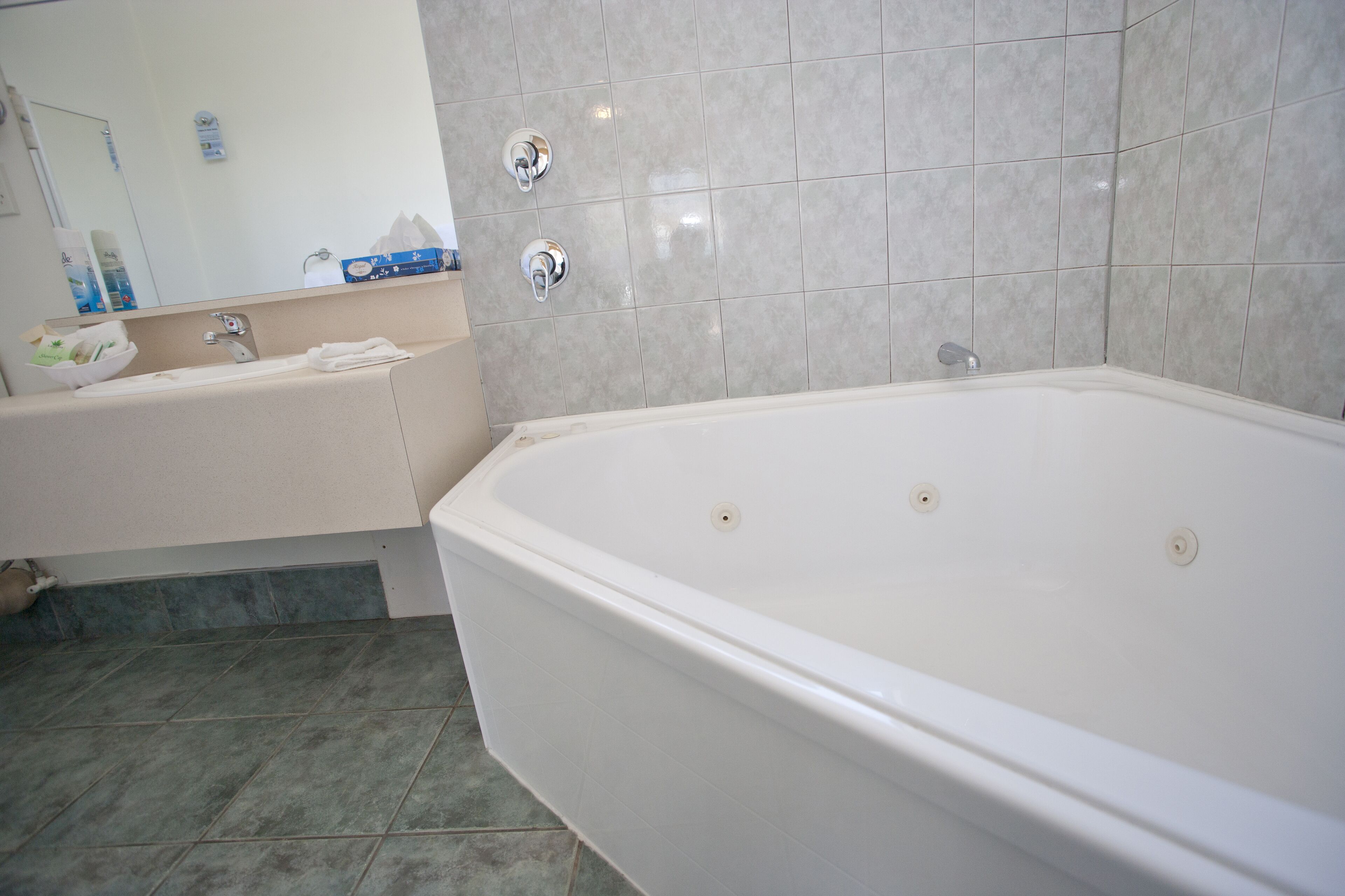 Un bany amb banyera, un lavabo i un mirall.