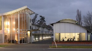 A modern building with large windows and a curved structure.