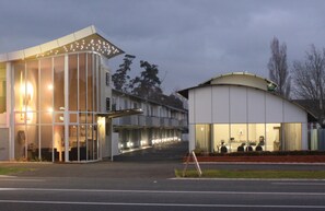 A modern building with large windows and a curved structure.