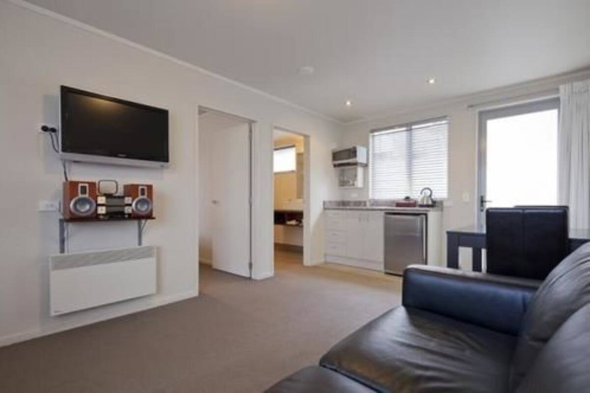 A modern living room with a flat-screen TV, a built-in sound system, and a comfortable sofa.